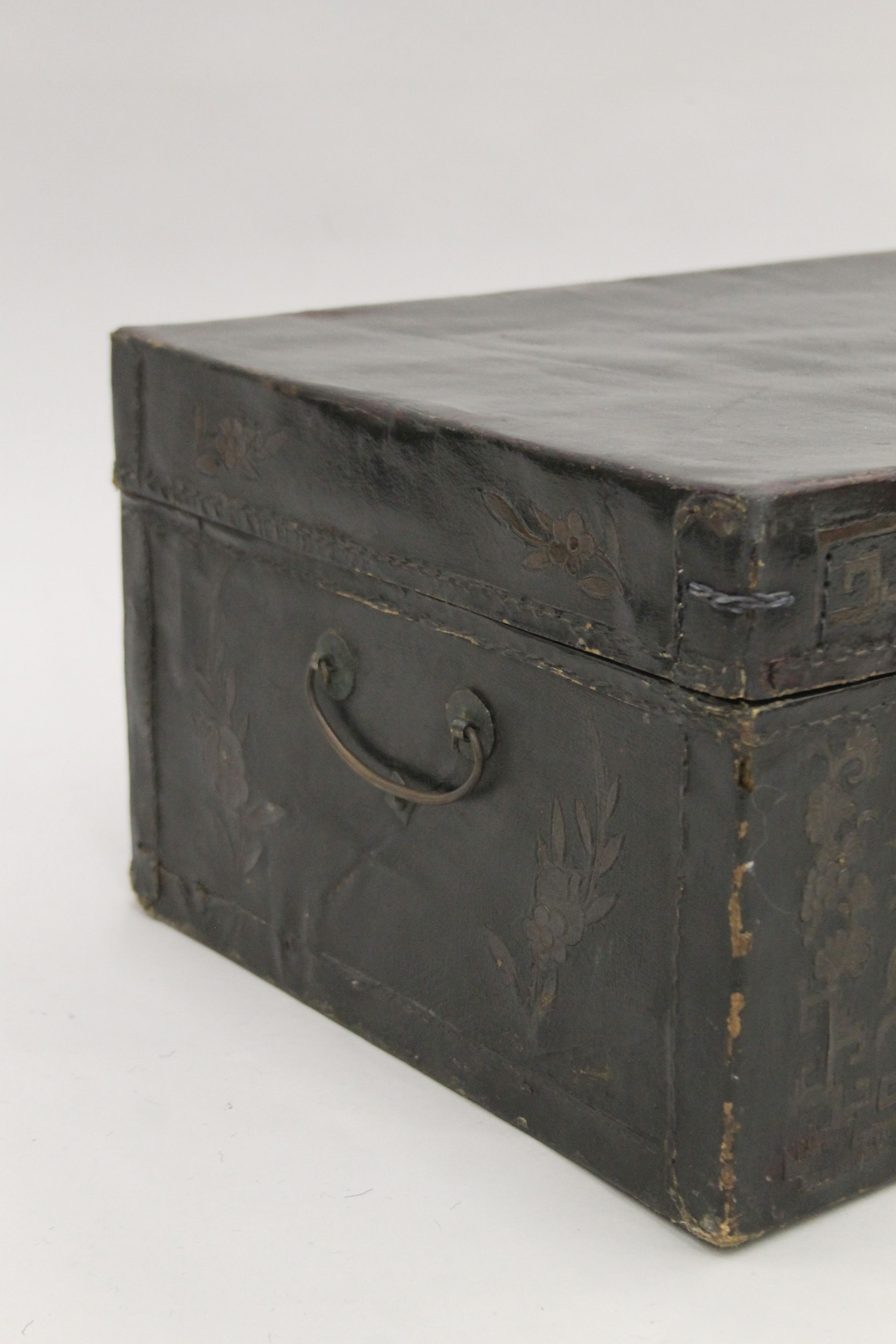A 19th century Chinese black leather trunk with flower decoration and brass fittings. 58 cm wide. - Image 3 of 4