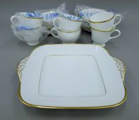 A quantity of Wedgwood gilt bounded porcelain tea wares and a cut glass perfume bottle.