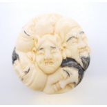 A bone faces netsuke. 4 cm diameter.