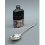 A silver plated serving spoon and a silver plated hip flask. The latter 17.5 cm high.