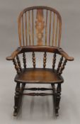 A 19th century elm seated Windsor rocking chair. 67 cm wide.