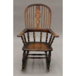 A 19th century elm seated Windsor rocking chair. 67 cm wide.