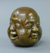 A four faced bronze Buddha head. 11 cm high.