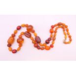 A Victorian Baltic amber necklace with engraved beads and gold clasp. 75 cm long. 64.