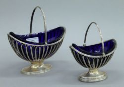 Two George III silver sugar baskets with blue glass liners, each hallmarked for London 1804,