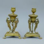 A pair of 19th century Empire style brass candlesticks, with phoenix supports and lion paw feet.