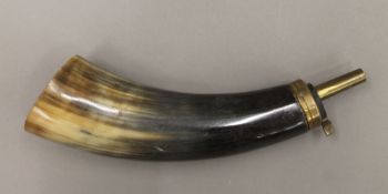 A horn and brass powder flask. 23 cm long.