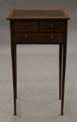 An Edwardian George III style satinwood crossbanded mahogany side table with three drawers. 40.