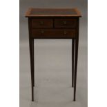 An Edwardian George III style satinwood crossbanded mahogany side table with three drawers. 40.