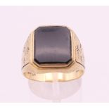 A 9 ct gold gentleman's onyx set ring. Ring size V. 7.4 grammes total weight.