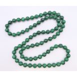 A string of malachite beads. 86 cm long.