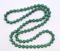 A string of malachite beads. 86 cm long.