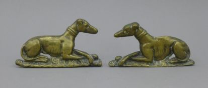 A pair of Victorian brass recumbent greyhound mantlepiece ornaments. 15 cm long.