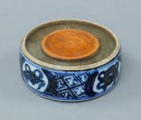 A small Chinese porcelain blue and white ink stone. 8 cm diameter.