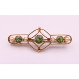 A 15 ct gold peridot and seed pearl brooch. 3.5 cm long. 3 grammes total weight.