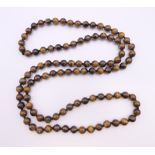 A string of tigerseye beads. 90 cm long.