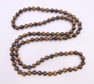 A string of tigerseye beads. 90 cm long.