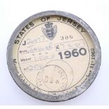 A 1960 States of Jersey Jaguar tax disk in a Jaguar tax disk holder. 7.75 cm diameter.