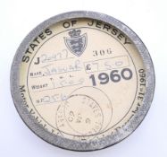 A 1960 States of Jersey Jaguar tax disk in a Jaguar tax disk holder. 7.75 cm diameter.