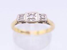 An 18 ct gold and platinum three stone diamond ring. Ring size O/P. 2.6 grammes total weight.