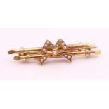 A 15 ct gold bar brooch decorated with a seed pearl bow. 4.5 cm long. 4.3 grammes total weight.