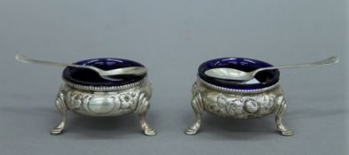 A pair of Victorian silver salts and a pair of silver spoons. The former 6 cm diameter.