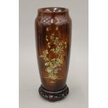 A 19th century Japanese turned wooden lacquered vase with mother-of-pearl inlay on a wooden stand