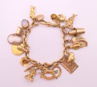 A 9 ct gold charm bracelet. 20 cm long. 61.9 grammes total weight.