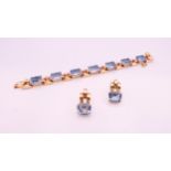 An 18 K rose gold bracelet and earrings set, set with blue stones possibly topaz.