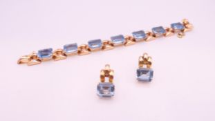 An 18 K rose gold bracelet and earrings set, set with blue stones possibly topaz.