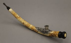 A Chinese bone pipe carved with a dragon. 35 cm long.