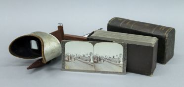 An aluminium and wooden stereo viewer, with boxed military in India stereo views.