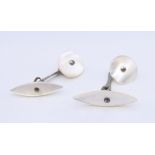 A pair of mother-of-pearl cufflinks. Oval shape 2.75 cm long, circle 1.5 cm diameter.