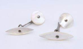 A pair of mother-of-pearl cufflinks. Oval shape 2.75 cm long, circle 1.5 cm diameter.