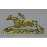 A brass mantle ornament formed as a racehorse with jockey up. 17 cm long.