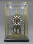 A brass skeleton clock in a glass case. 54 cm high overall.