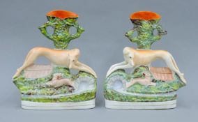 A pair of 19th century Staffordshire pottery coursing spill figures of a greyhound coursing a hare