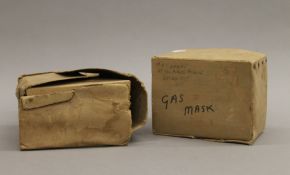 Two boxed WWII gas masks.