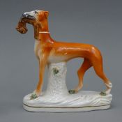 A 20th century Staffordshire pottery model of a coursing greyhound with a hare in its mouth,