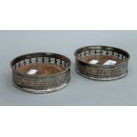 A pair of silver plated bottle coasters. 13 cm diameter.