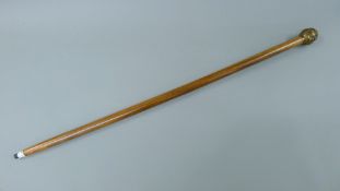 A walking stick with a four faced Buddha head formed handle. 92 cm long.