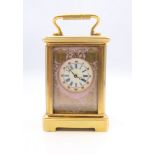 A porcelain mounted miniature carriage clock. 6 cm high.