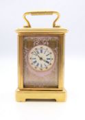 A porcelain mounted miniature carriage clock. 6 cm high.