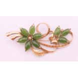 An 18 K gold and jade floral spray brooch. 7 cm long. 11.5 grammes total weight.