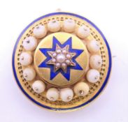 An unmarked enamel and seed pearl set mourning brooch. 3.75 cm diameter.