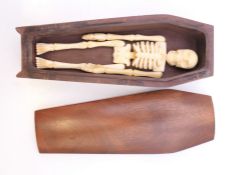 A miniature coffin enclosing a bone skeleton. Coffin 12 cm long.