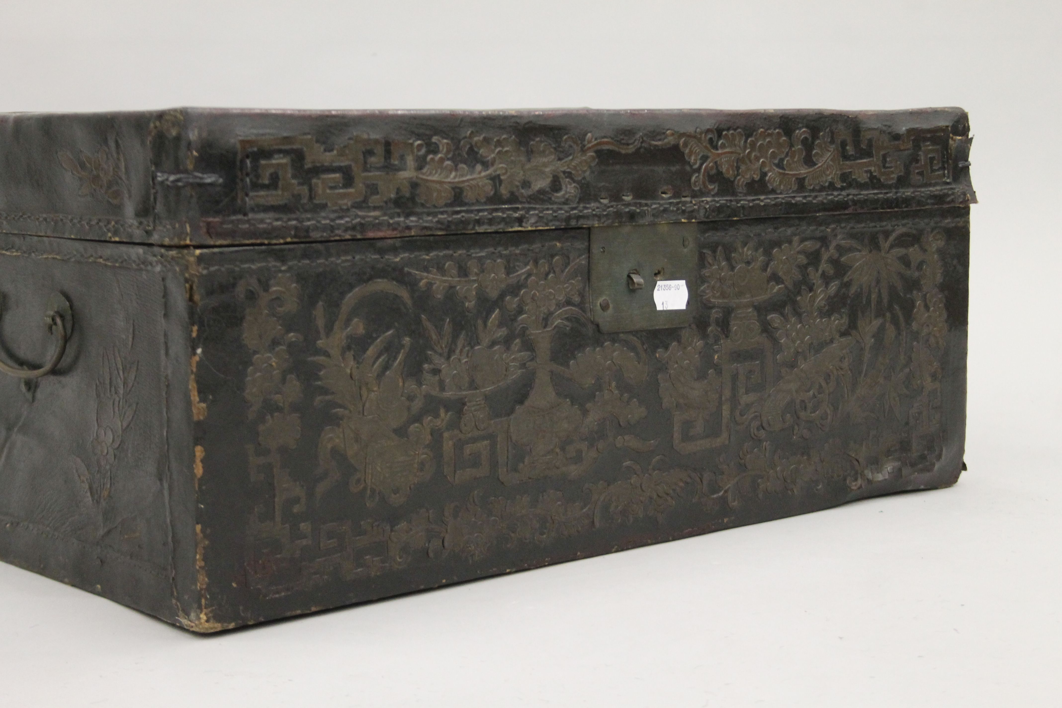 A 19th century Chinese black leather trunk with flower decoration and brass fittings. 58 cm wide. - Image 2 of 4