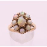 A mid-20th century 9 ct gold opal oval cluster ring. Ring size O. 4.1 grammes total weight.