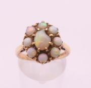 A mid-20th century 9 ct gold opal oval cluster ring. Ring size O. 4.1 grammes total weight.