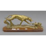 A brass model of a greyhound coursing a hare, on a polished wooden base. 45 cm long.